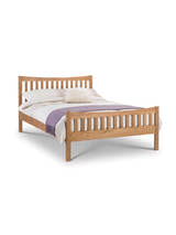 Julian Bowen Bergamo oak bed made up with a lilac throw, on a white background