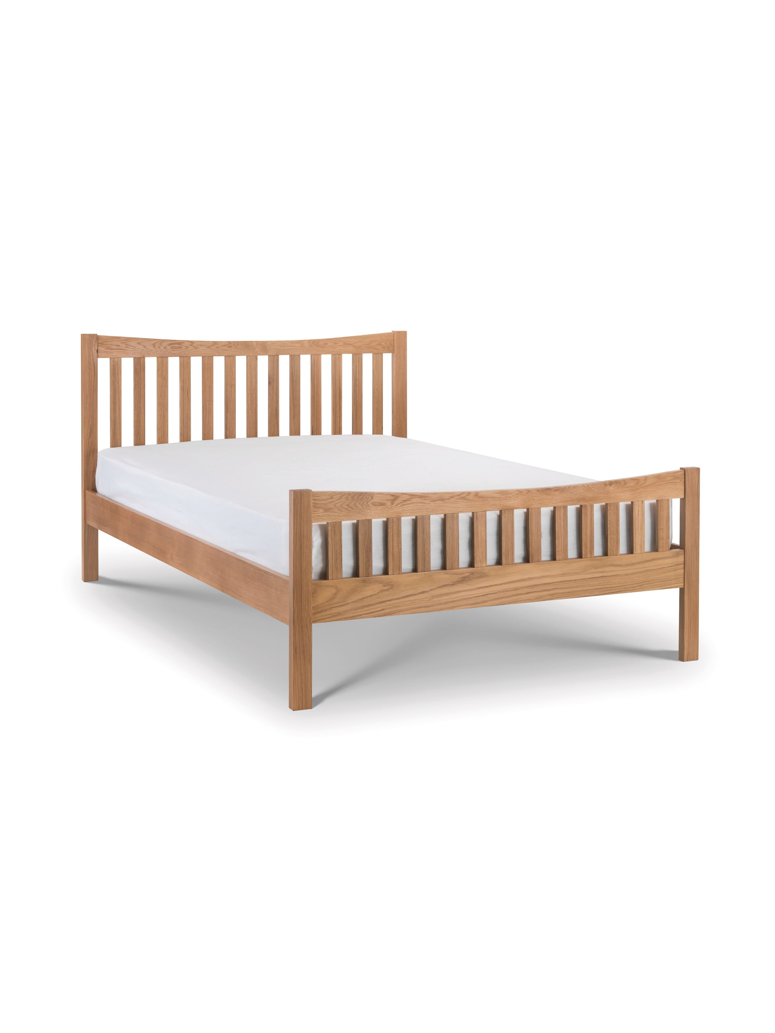 Julian Bowen Bergamo oak bed with a bare mattress, showing the curved headboard and slatted footend