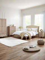 Camille limed oak bed with matching bedroom furniture, in a large room with wooden floor