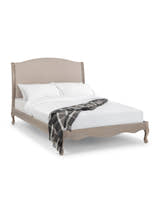 Julian Bowen Camille limed oak bed made up with a checked throw, on a white background