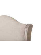 Camille bed: corner of the curved oatmeal linen headboard and its limed oak frame, close up