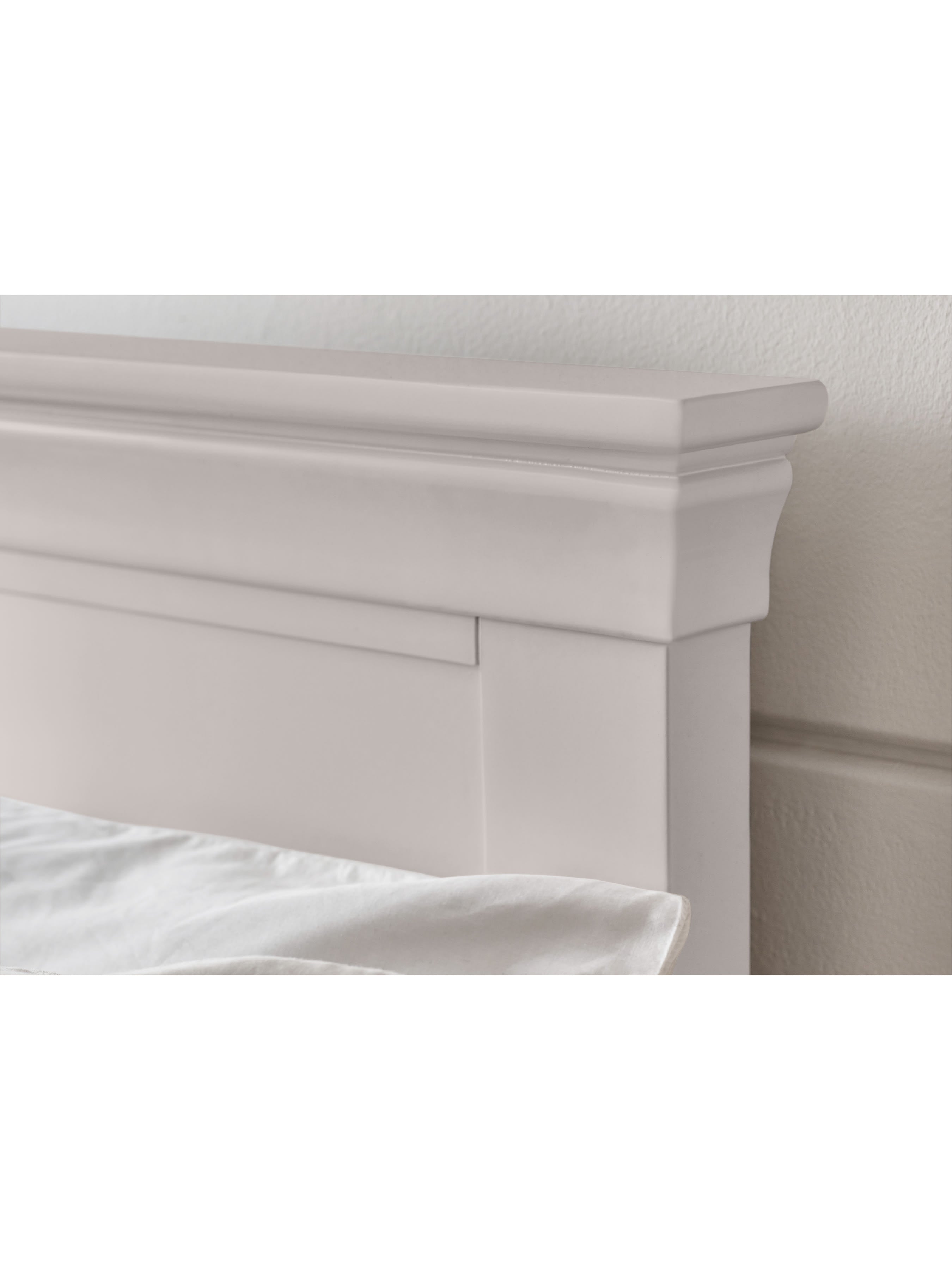 Clermont bed: the tapered cornice of the light grey headboard, close up