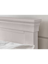 Clermont bed: the tapered cornice of the light grey headboard, close up
