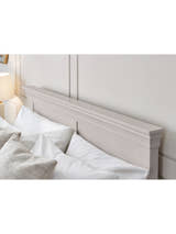 Clermont bed: the light grey headboard with its tapered cornice, behind pillows