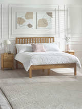Julian Bowen Coxmoor oak bed with a tall slatted headboard, in a white panelled bedroom