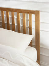 Coxmoor bed: oiled oak slatted headboard behind the pillows, close up