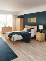 Julian Bowen Curve oak bed in a large bedroom with matching oak furniture, wide view