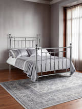 Julian Bowen Empress chrome bed with a high headboard and footboard, in a bedroom with a grey rug