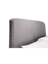 Frida bed: curved grey velvet headboard behind a pillow, close up