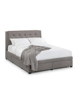 Julian Bowen Fullerton grey linen 4 drawer bed made up with bedding, on a white background