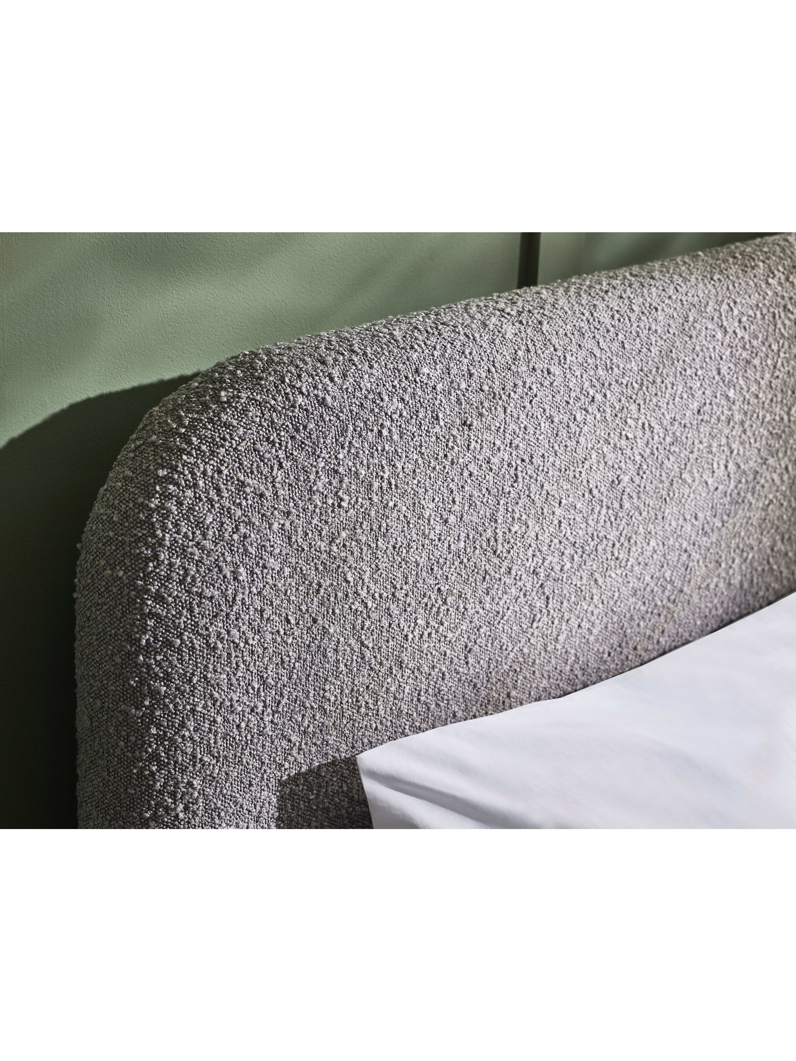 Hannah bed: the curved grey boucle headboard, close up