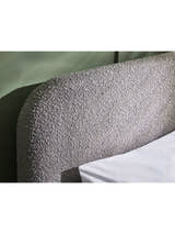 Hannah bed: the curved grey boucle headboard, close up