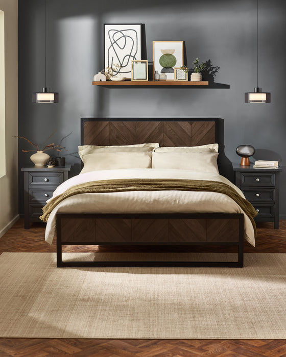 Julian Bowen Harrison black metal bed with dark oak herringbone panels, in a dark blue bedroom