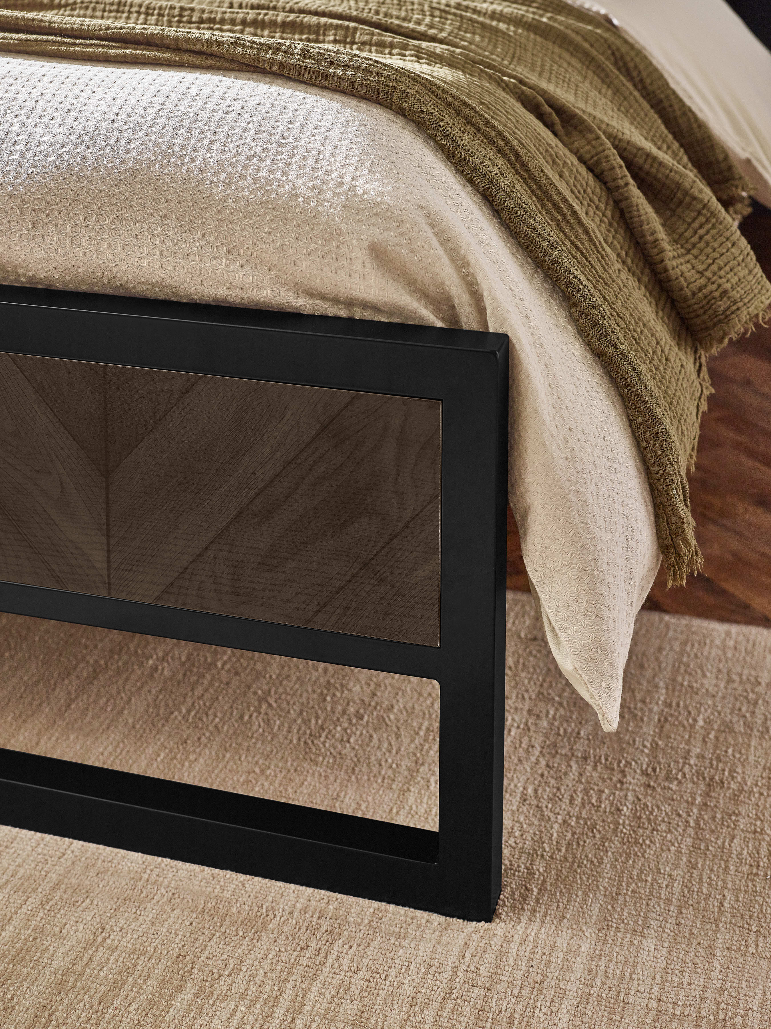 Harrison bed: black metal footboard with a herringbone effect panel, close up