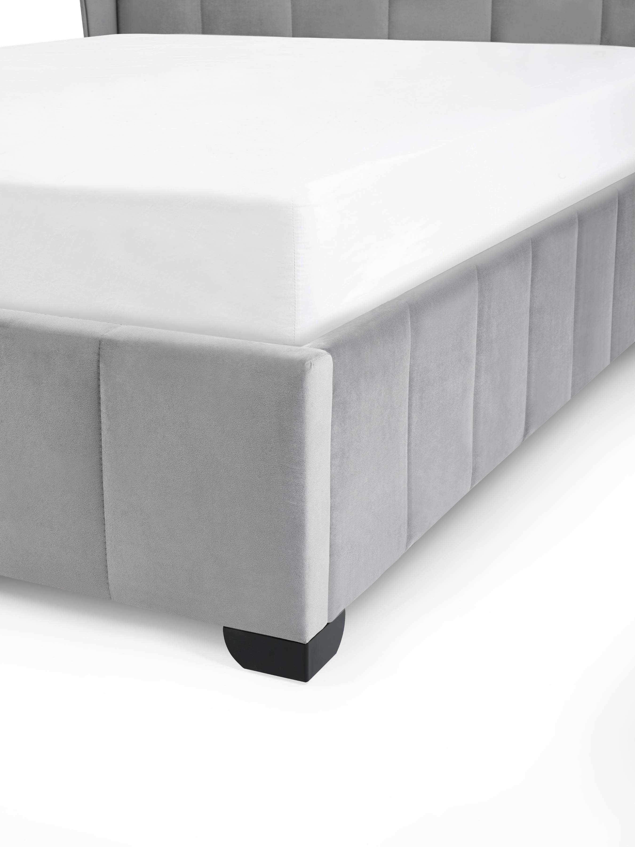 Katie bed: corner of the panelled velvet base and its dark foot, close up