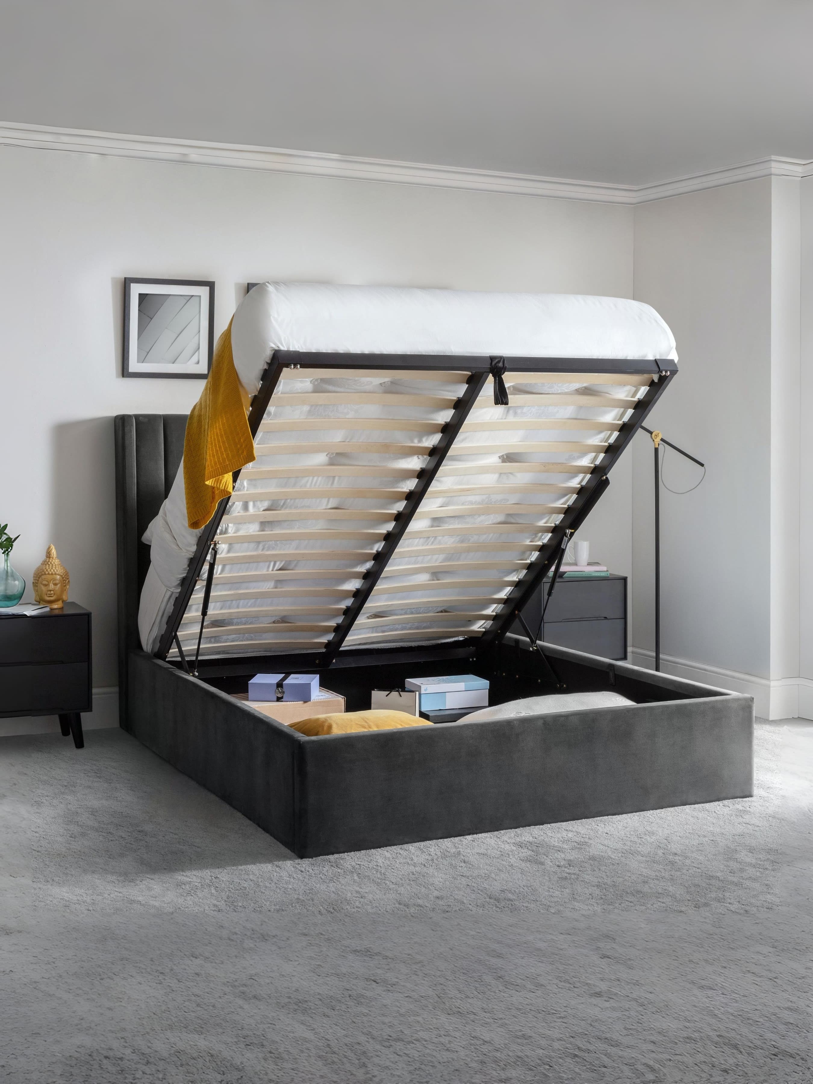 Langham ottoman bed with the base lifted to show the storage, in a bedroom