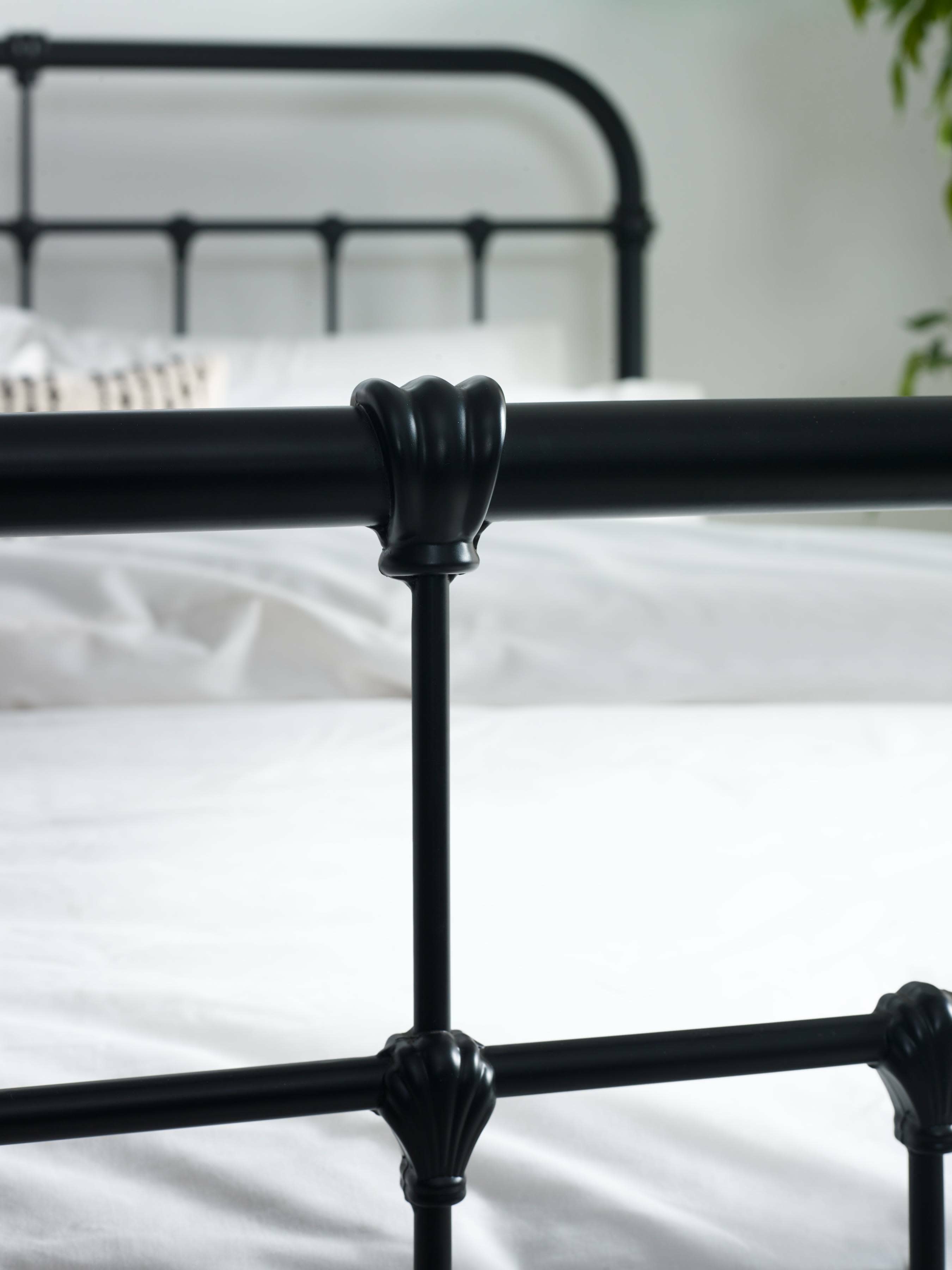 Logan bed: a cast detail on a black upright, close up