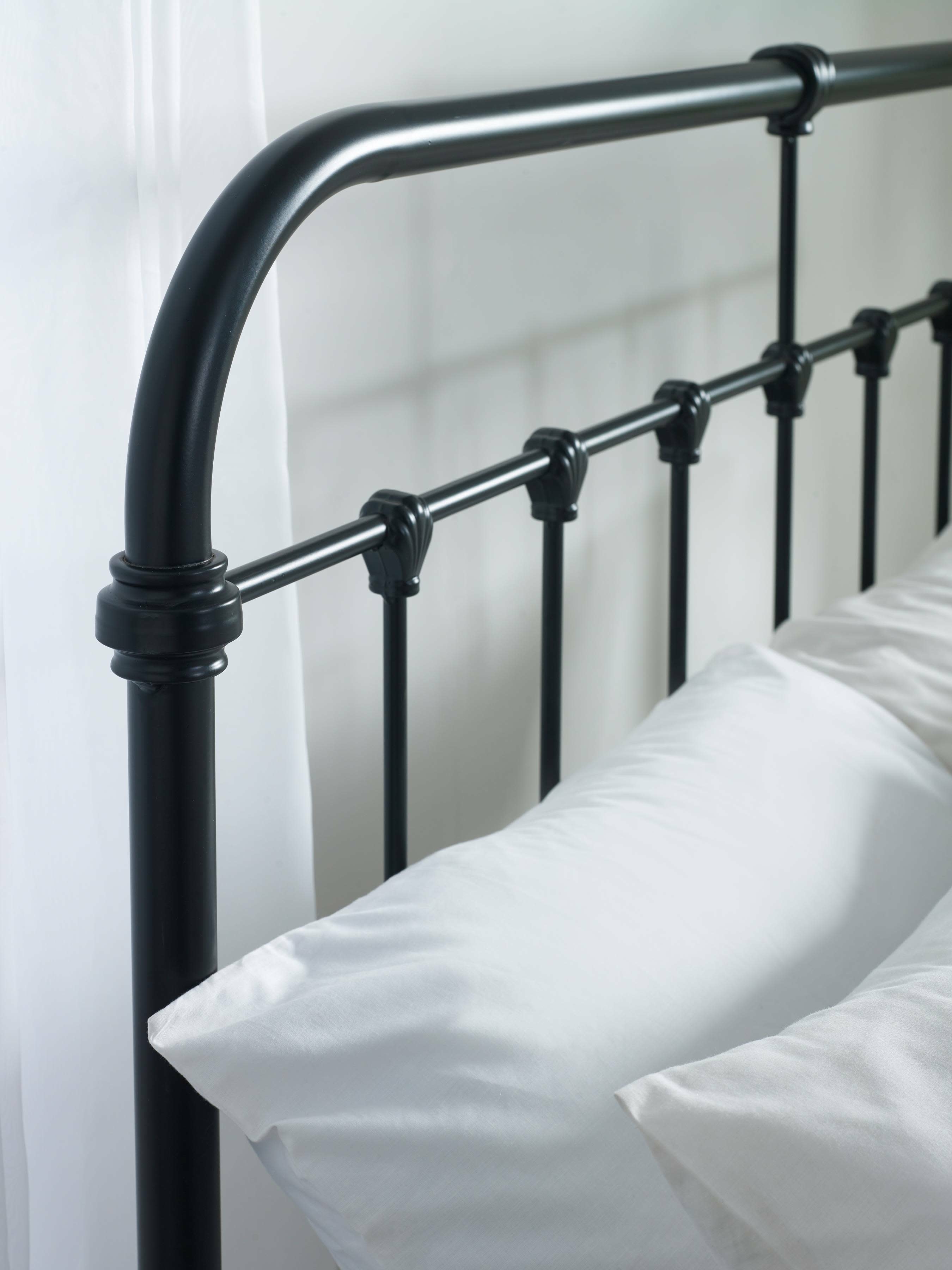Logan bed: the curved corner of the black headboard, close up