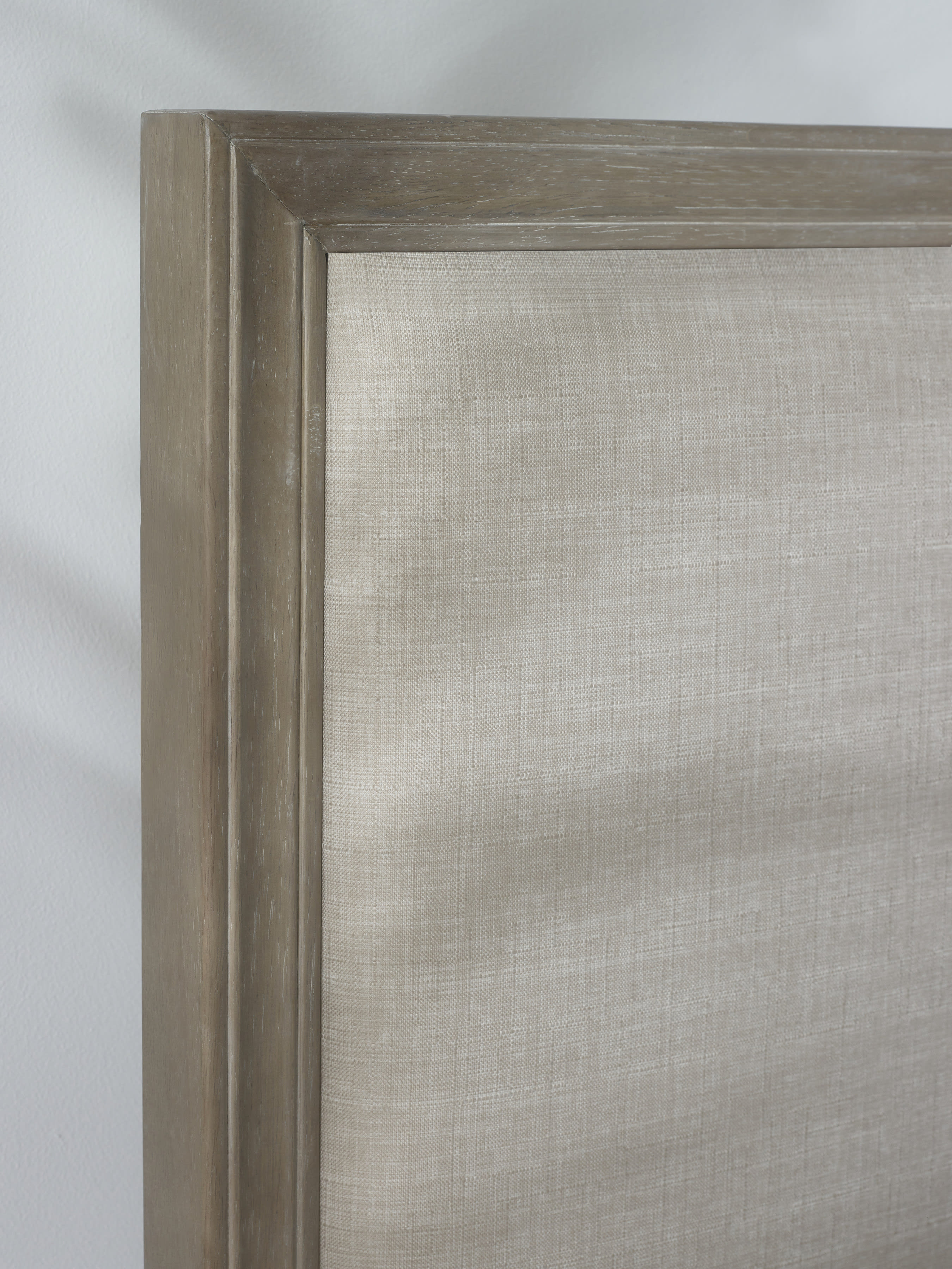 Lucie bed: limed oak border around the linen headboard, close up
