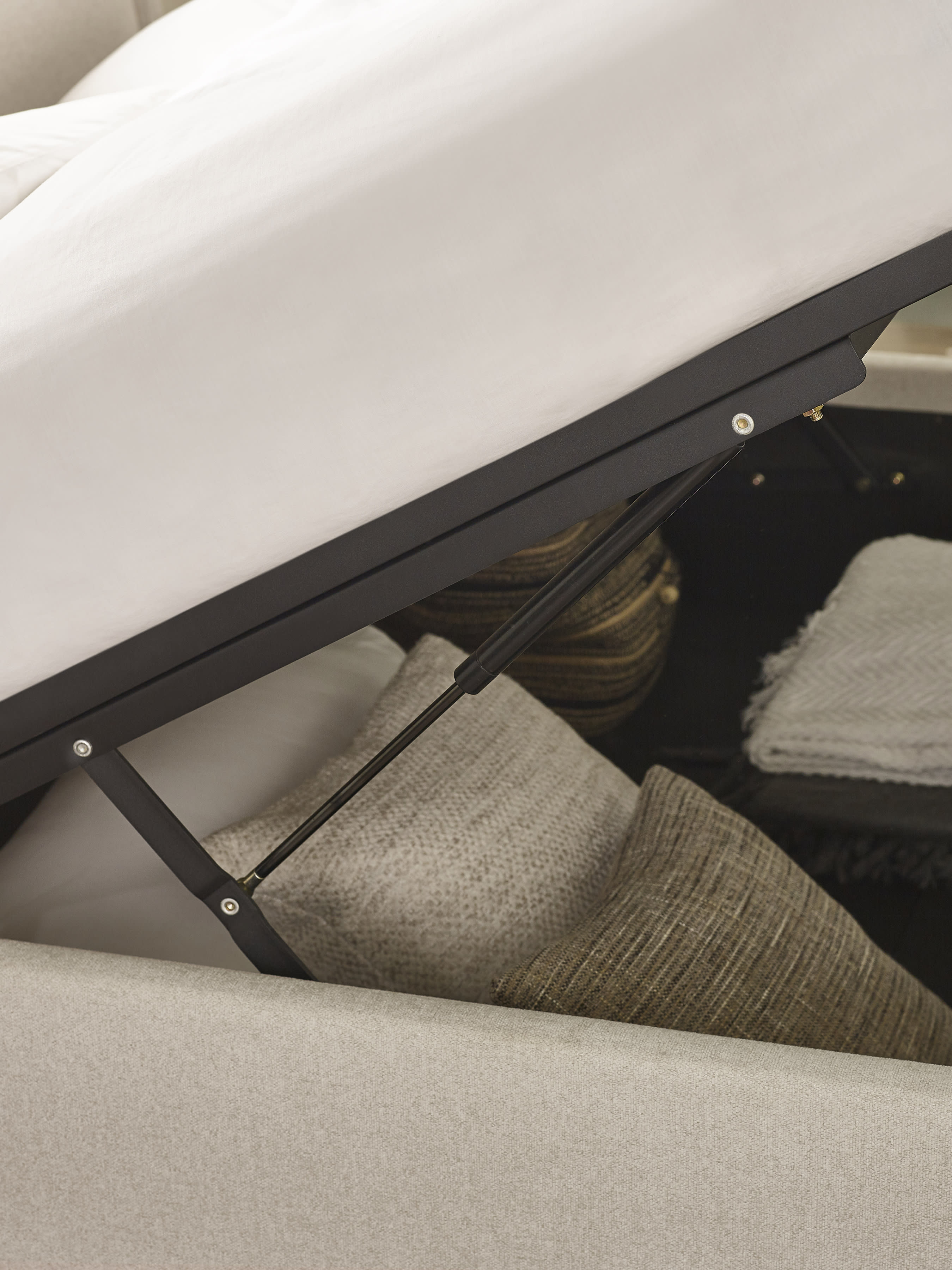 Maddock ottoman bed: lift mechanism above stored cushions, close up