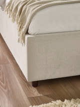 Maddock bed: corner of the beige base and its dark foot, close up