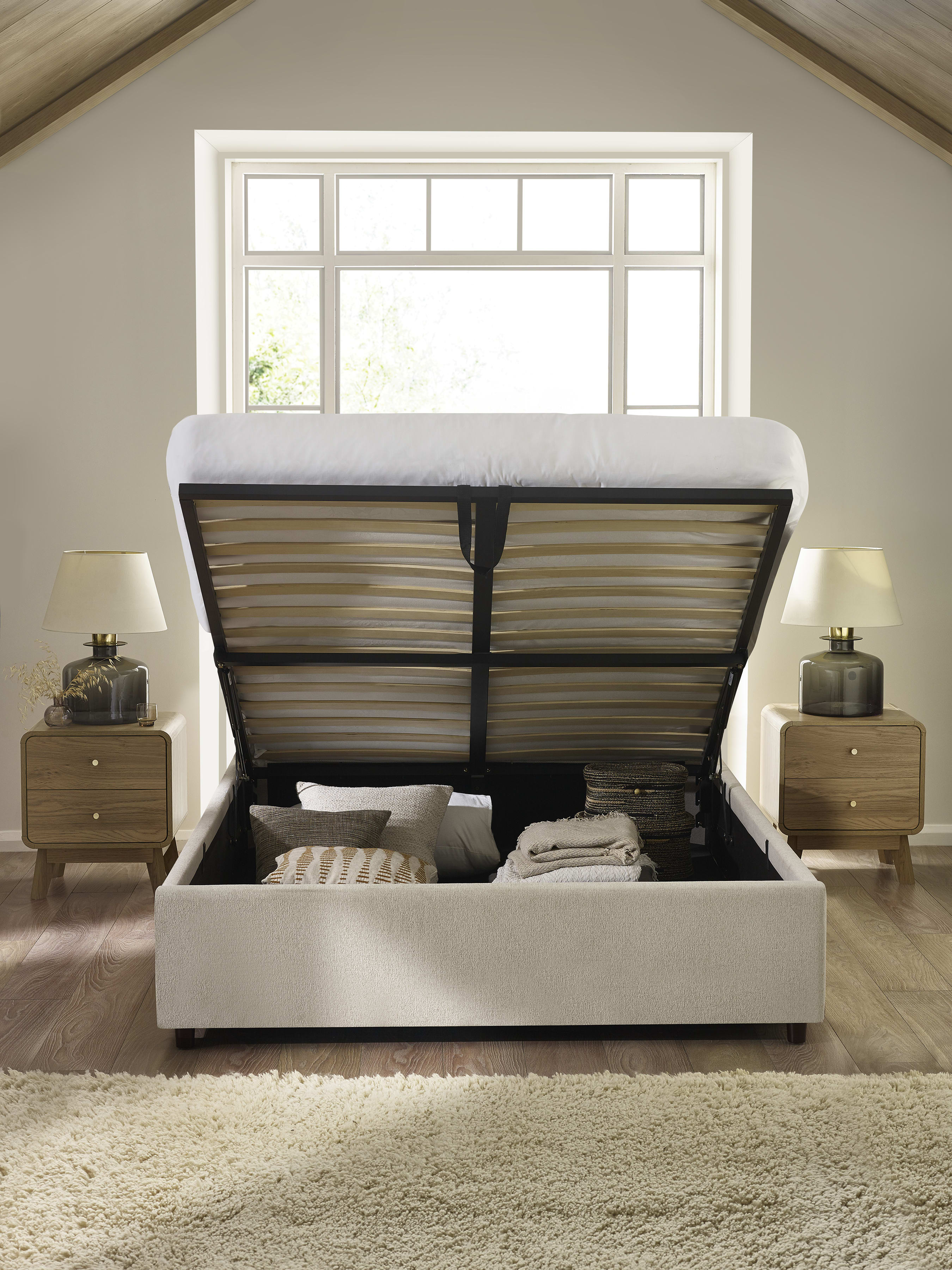 Maddock ottoman bed with the base lifted to show the storage, in a bedroom