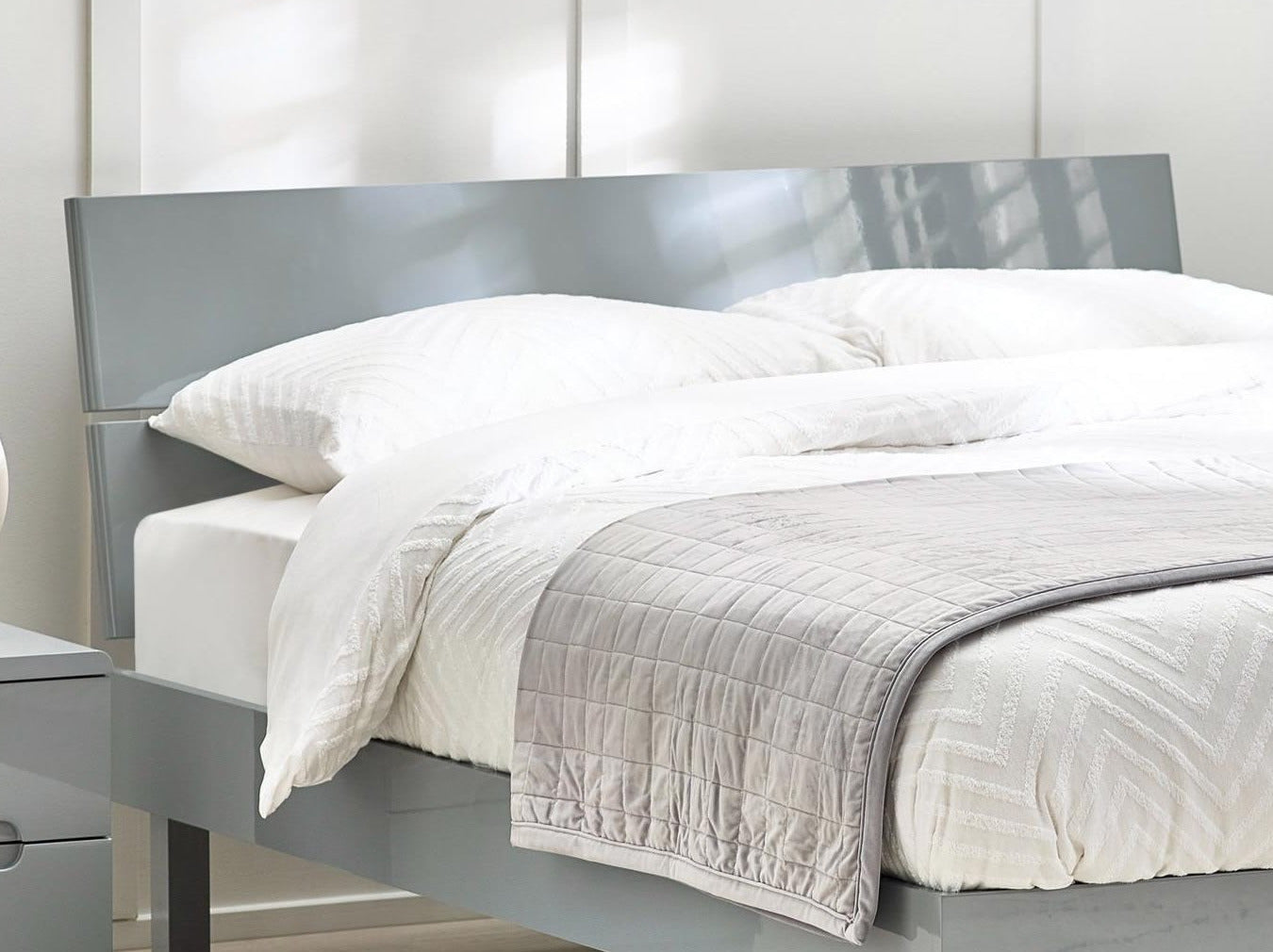 Julian Bowen Manhattan grey high gloss headboard in a bedroom, close up