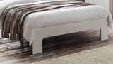 Julian Bowen Manhattan white high gloss footend and block legs on a wooden floor, close up