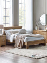 Julian Bowen Memphis limed oak bed with a panelled headboard, in a bright bedroom