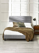 Julian Bowen Merida grey linen bed with a channelled headboard, in a bright bedroom