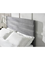 Merida bed: grey headboard padded in horizontal channels, behind pillows