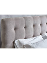 Odette bed: tall buttoned headboard behind white pillows, close up
