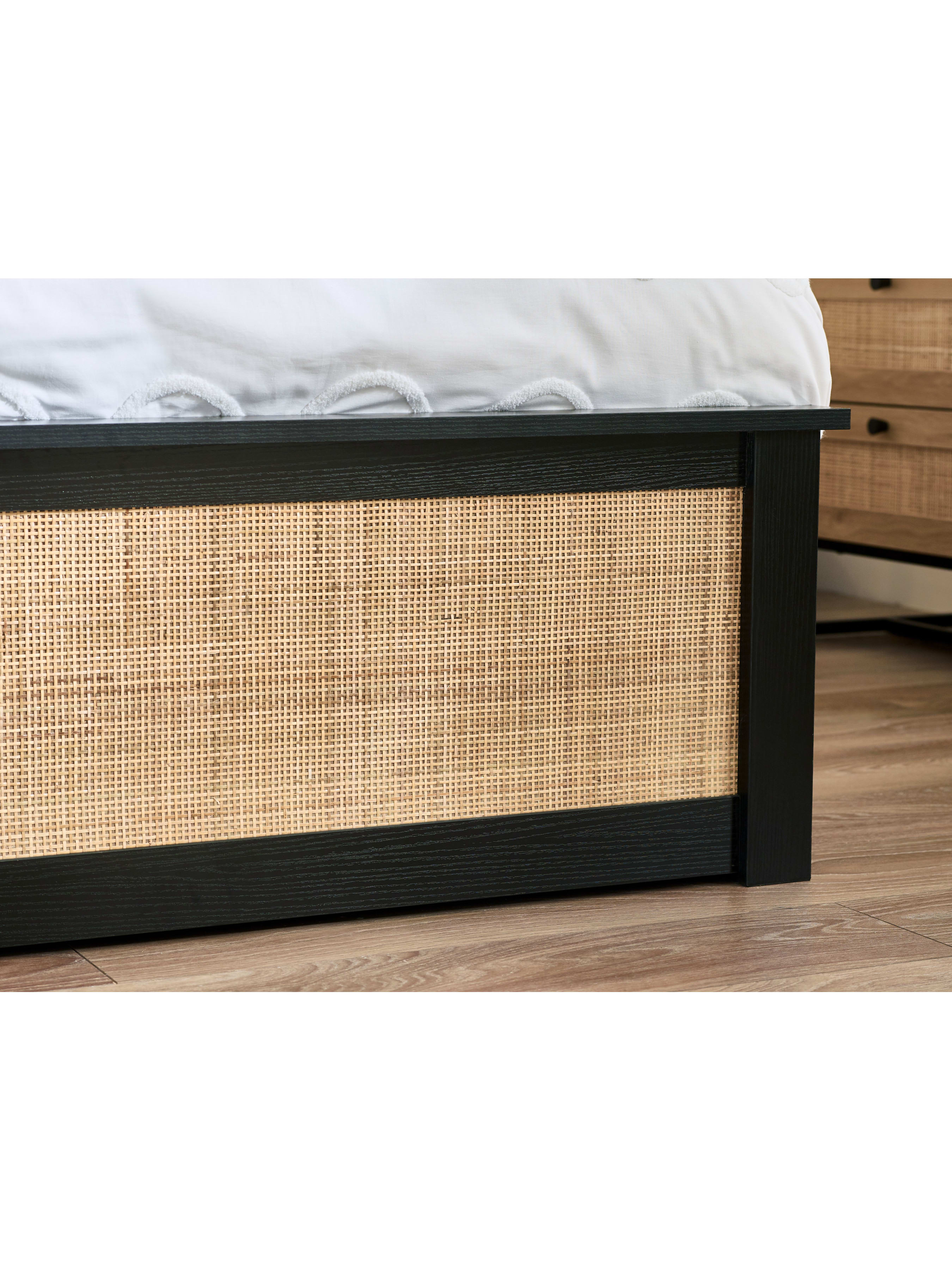 Padstow ottoman bed: black footboard with a woven rattan panel, close up