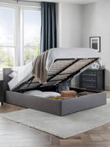 Julian Bowen Rialto grey ottoman bed with the base lifted to show the storage, in a bedroom