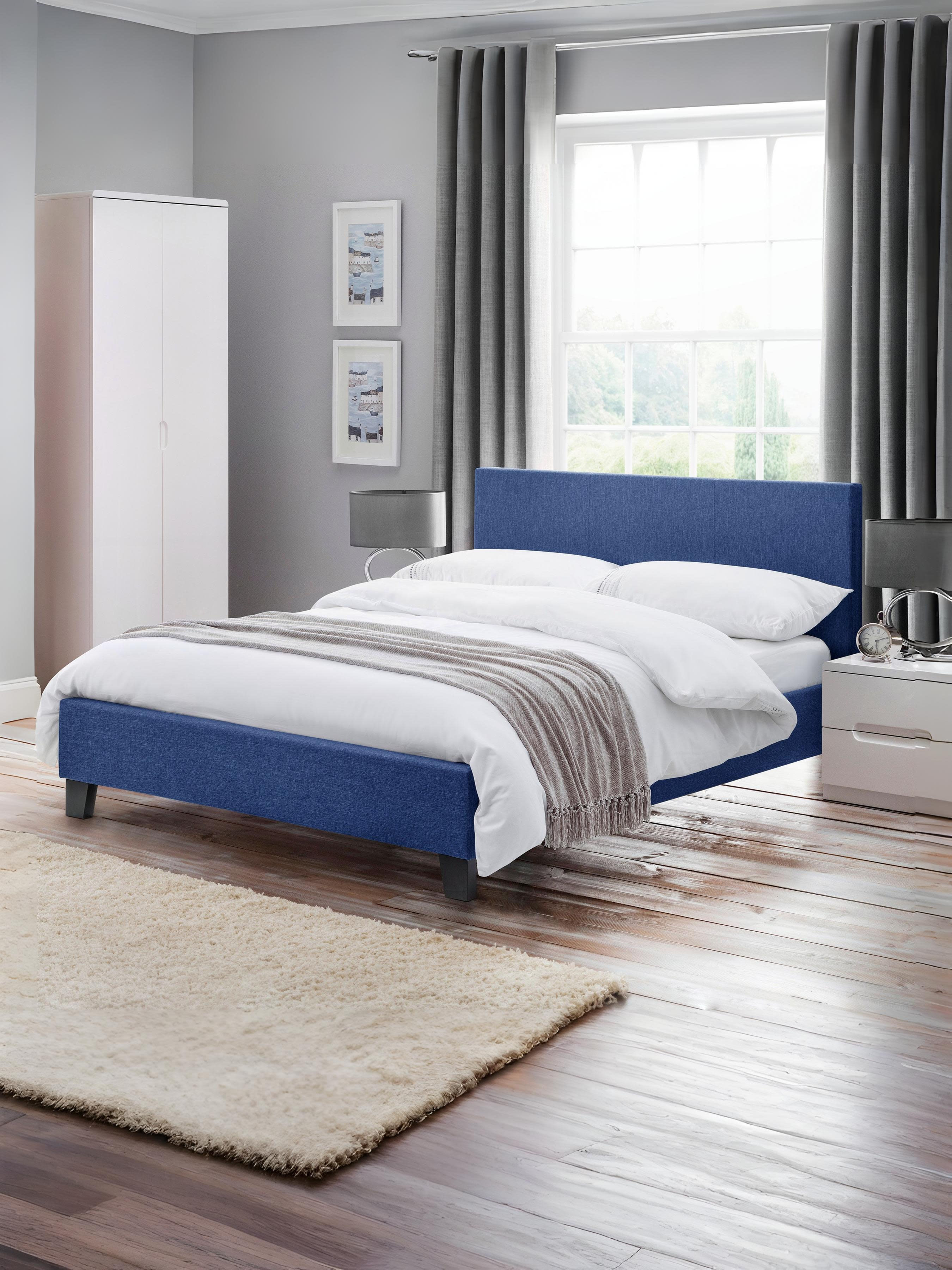 Julian Bowen Rialto upholstered bed in blue linen, in a bright bedroom with a wooden floor