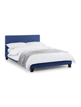 Julian Bowen Rialto blue linen bed made up with white bedding, on a white background