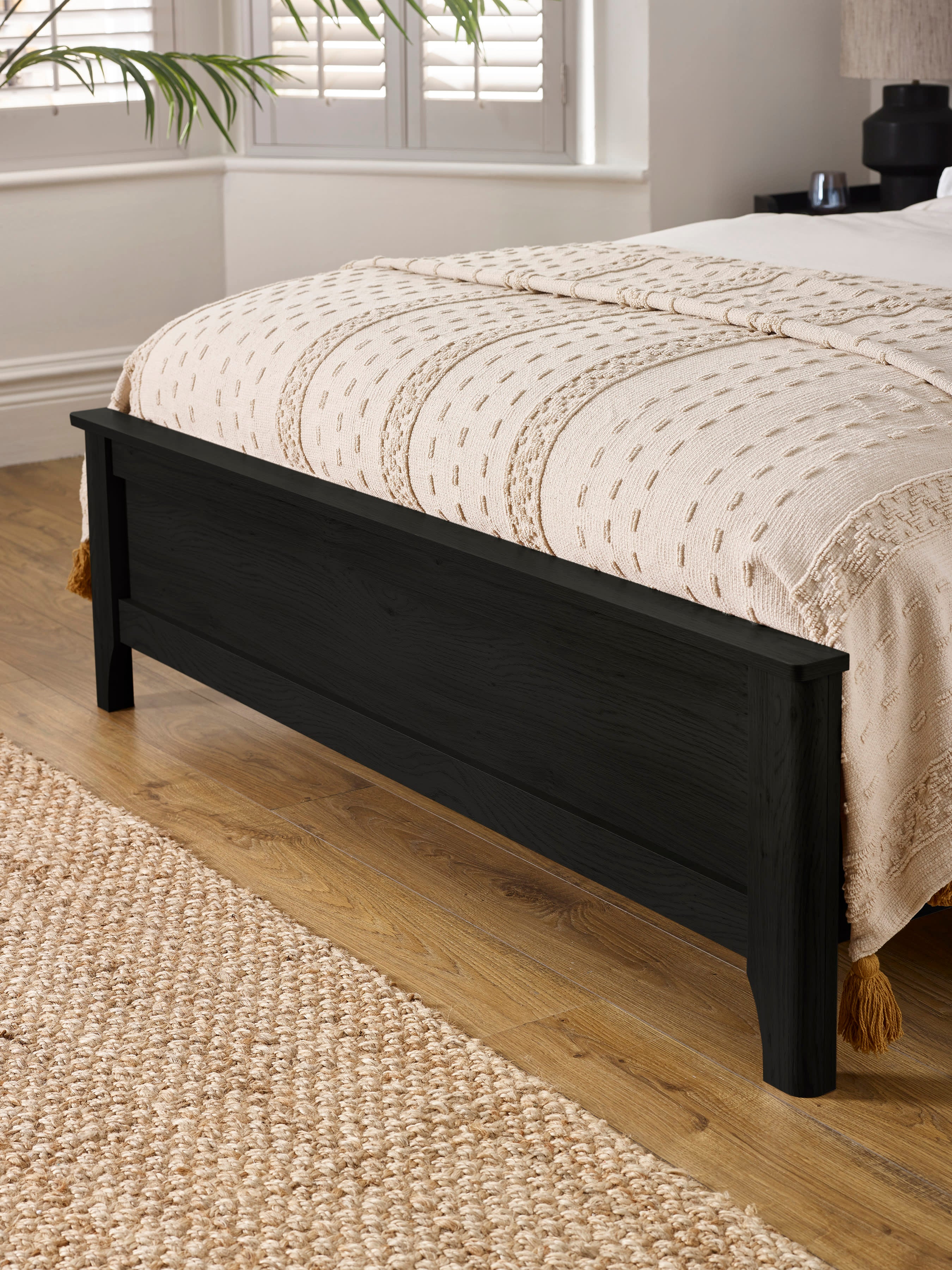 Sydney bed: black ash effect footboard with a softly shaped leg, close up