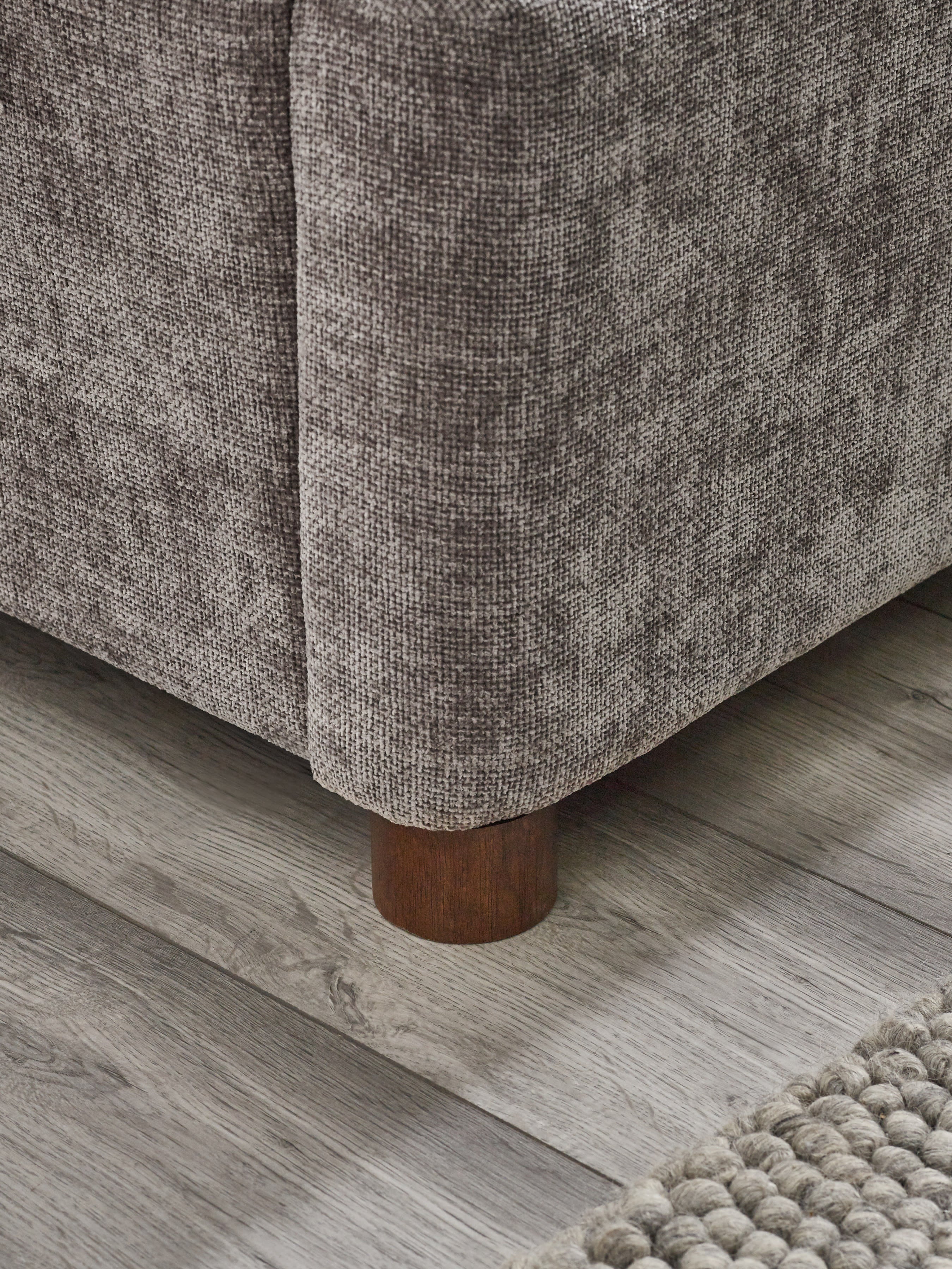 Whitmore bed: the grey chenille base and round wooden foot, close up