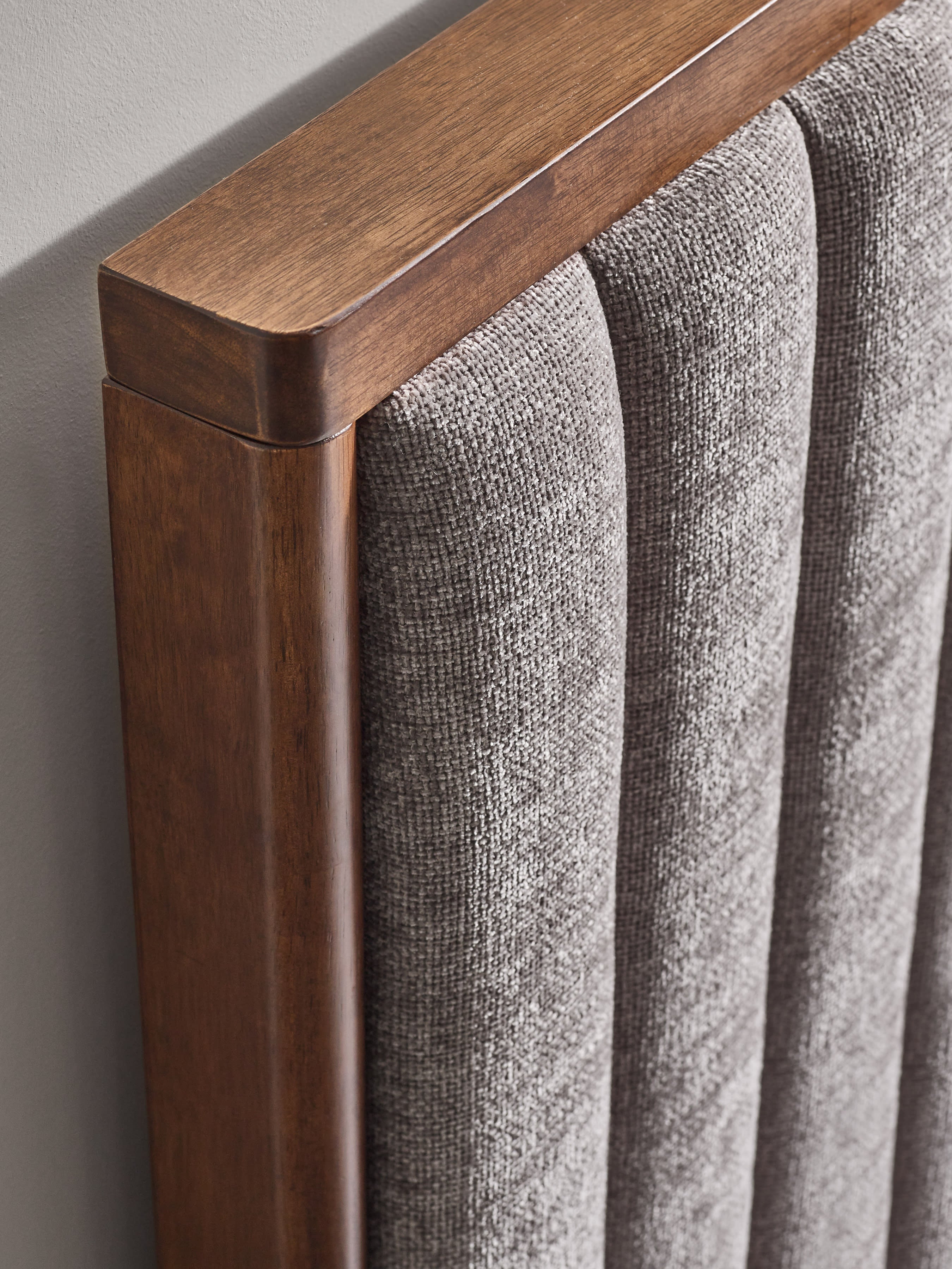 Whitmore bed: corner of the wooden headboard frame and chenille channels, close up