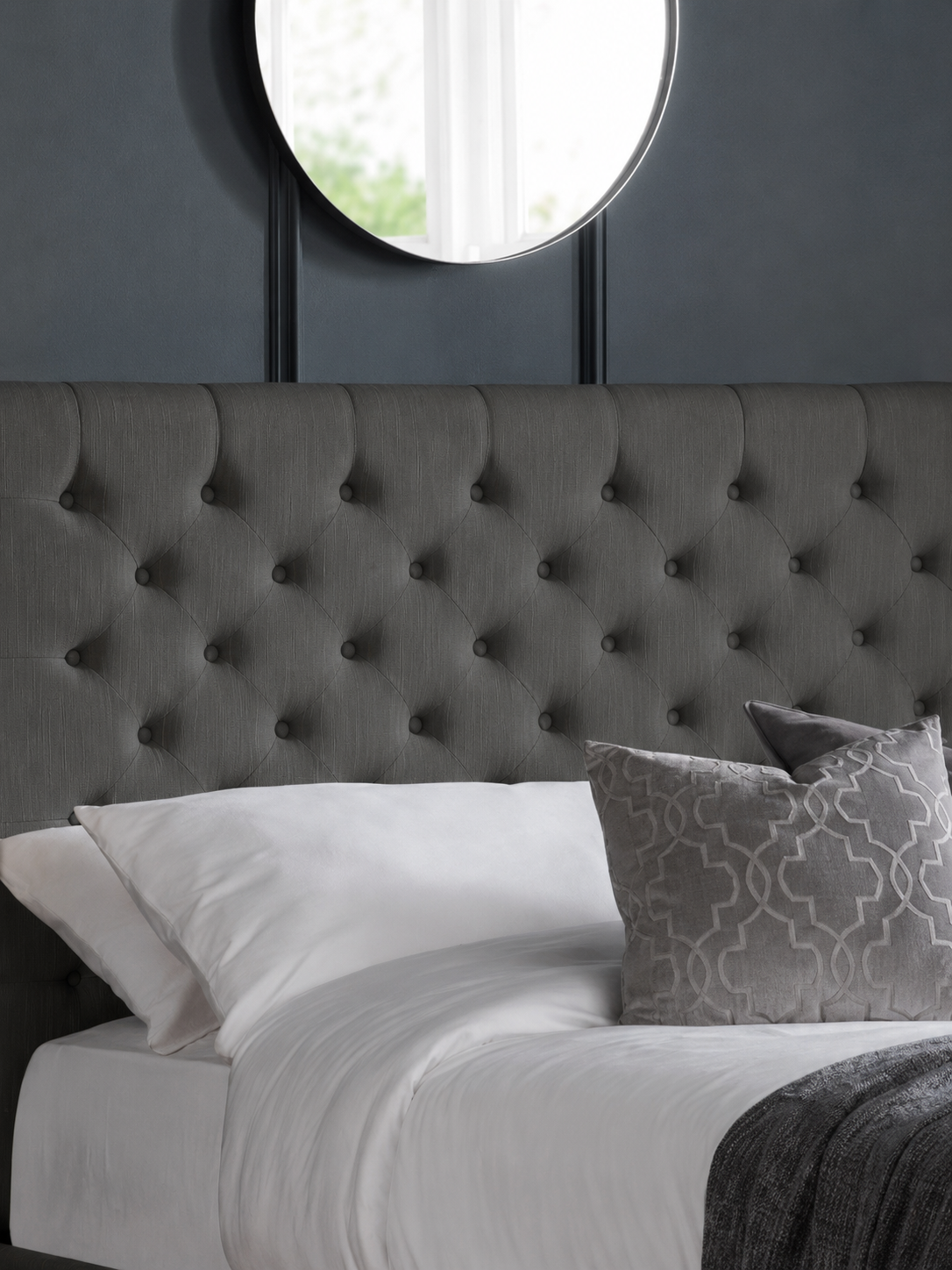 Wilton bed: the dark grey deep buttoned headboard with pillows, close up