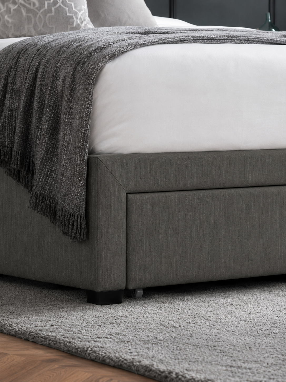 Wilton bed: a dark grey drawer front at the foot of the bed, close up