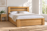 Chiswick solid oak ottoman bed in a natural oak finish, king size, in a bright UK bedroom (bedding for illustration, mattress not included)
