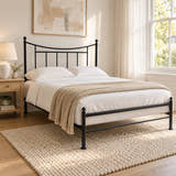 Walthamstow black metal bed frame with a low foot end, in a bright bedroom (AI-generated illustration of this frame; bedding for illustration, mattress not included)