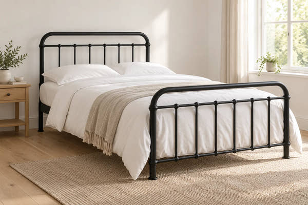 Miami black metal bed frame with curved rails, shown in a bright UK bedroom