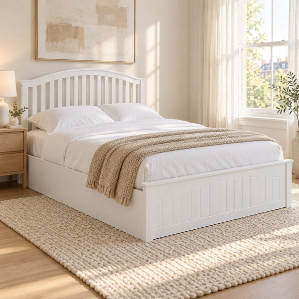 Barnet white wooden ottoman bed with a curved slatted headboard, in a bright bedroom