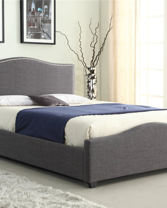 Bexley grey fabric ottoman bed with a curved studded headboard, in a bedroom