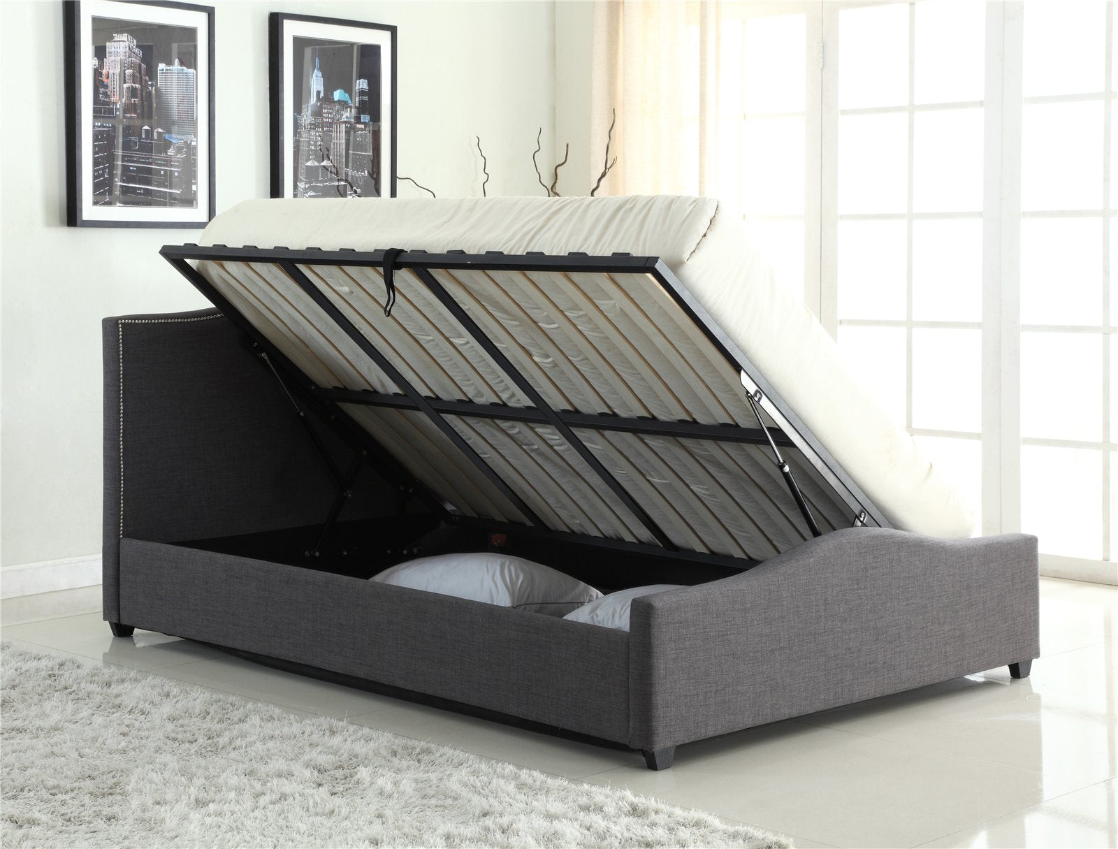 Bexley grey fabric ottoman bed with the base lifted to show the storage