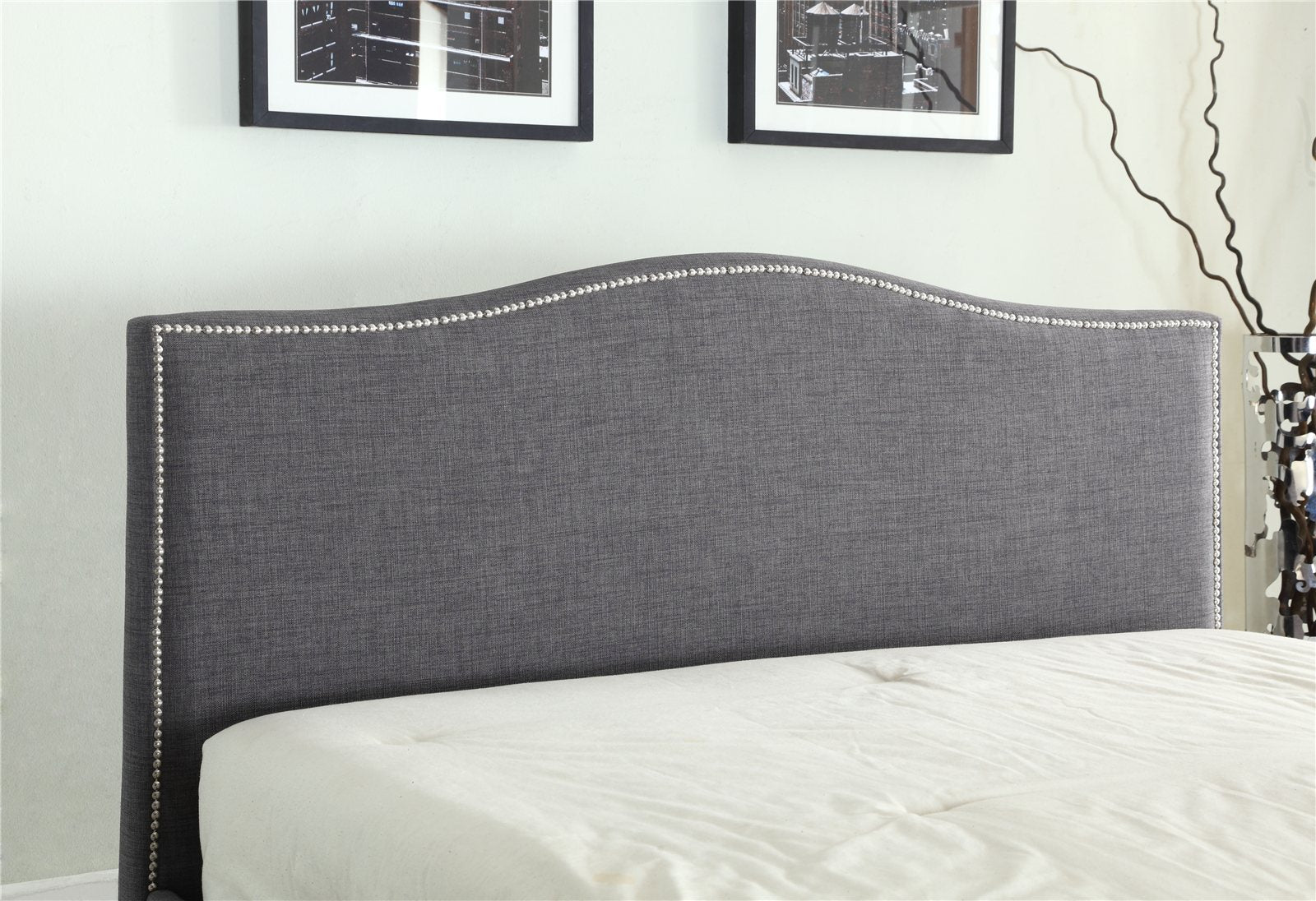 Bexley ottoman bed: curved grey fabric headboard with a studded edge, close up