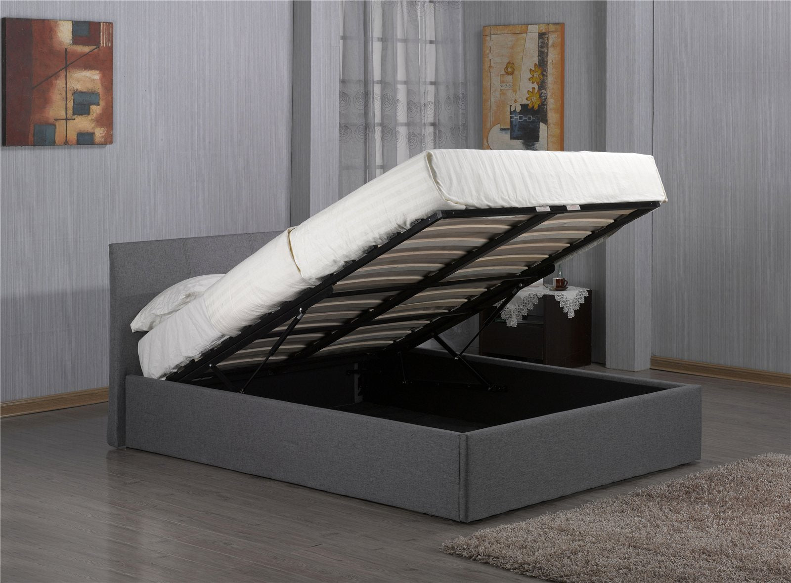 Harlesden grey fabric ottoman bed with the base lifted to show the storage