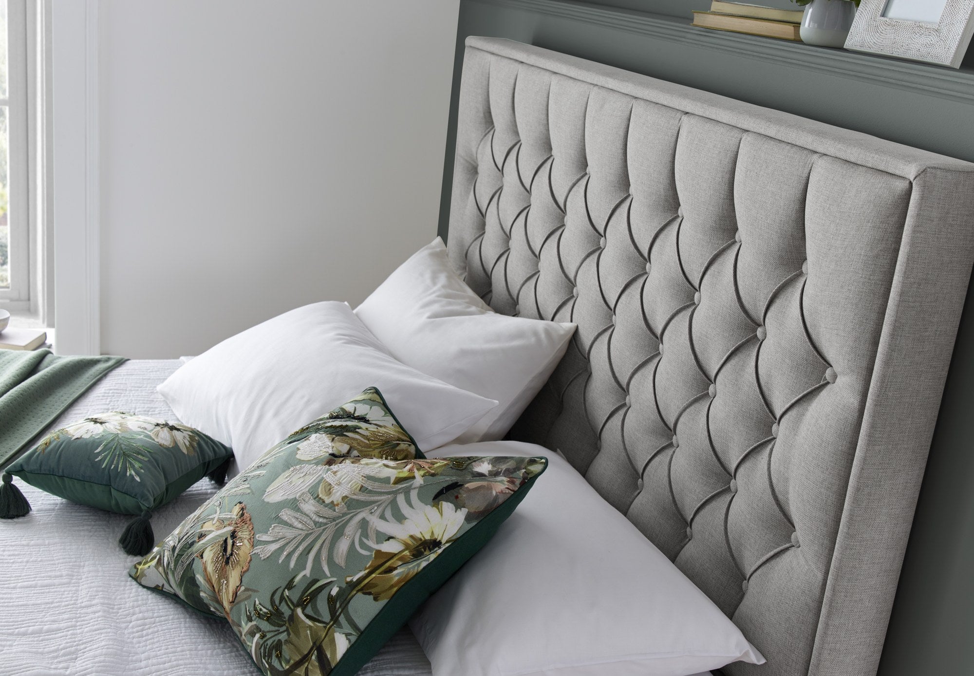 Wembley fabric ottoman bed in grey, close-up of the buttoned headboard